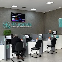 Recepção da Dr. Atende, com quatro guichês numerados de atendimento e cadeiras de espera