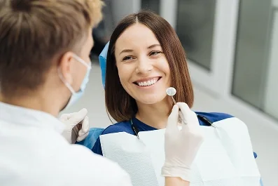 Paciente sorrindo na cadeira odontológica durante atendimento